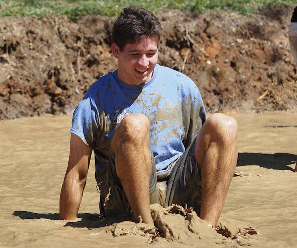 Student sitting in the muddy water.